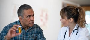 hispanic-male-patient-discussing-prescription-medication-with-female-doctor