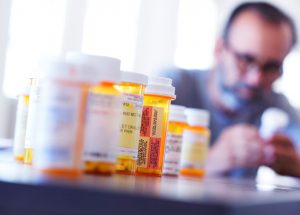 male-patient-with-many-medication-prescription-bottles